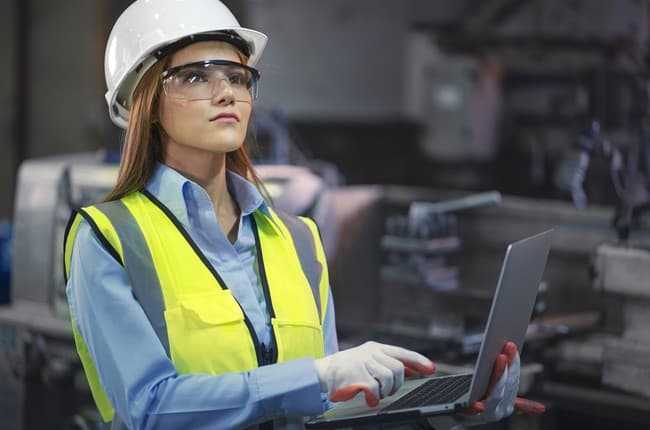 Female technician using laptop in field